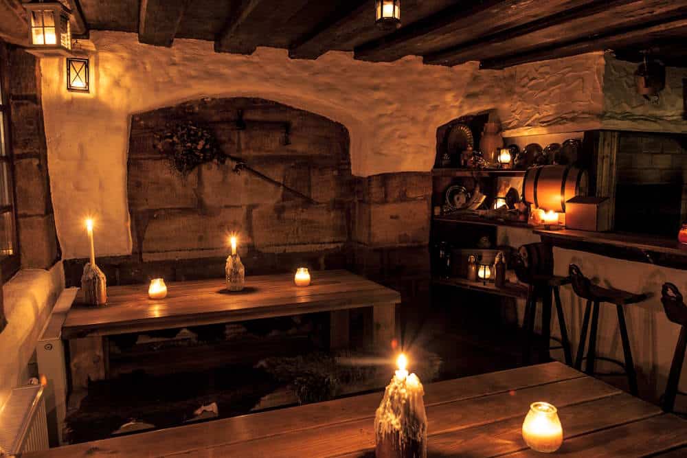 Finyas Taverne uriger Raum mit Kerzen und Fass