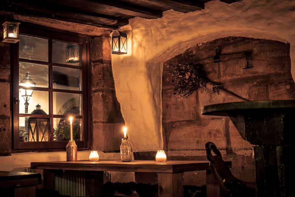 Finyas Taverne uriger Raum Tisch mit Kerzen